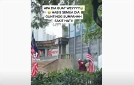 Polis kesan lelaki berbaju merah gunting Jalur Gemilang